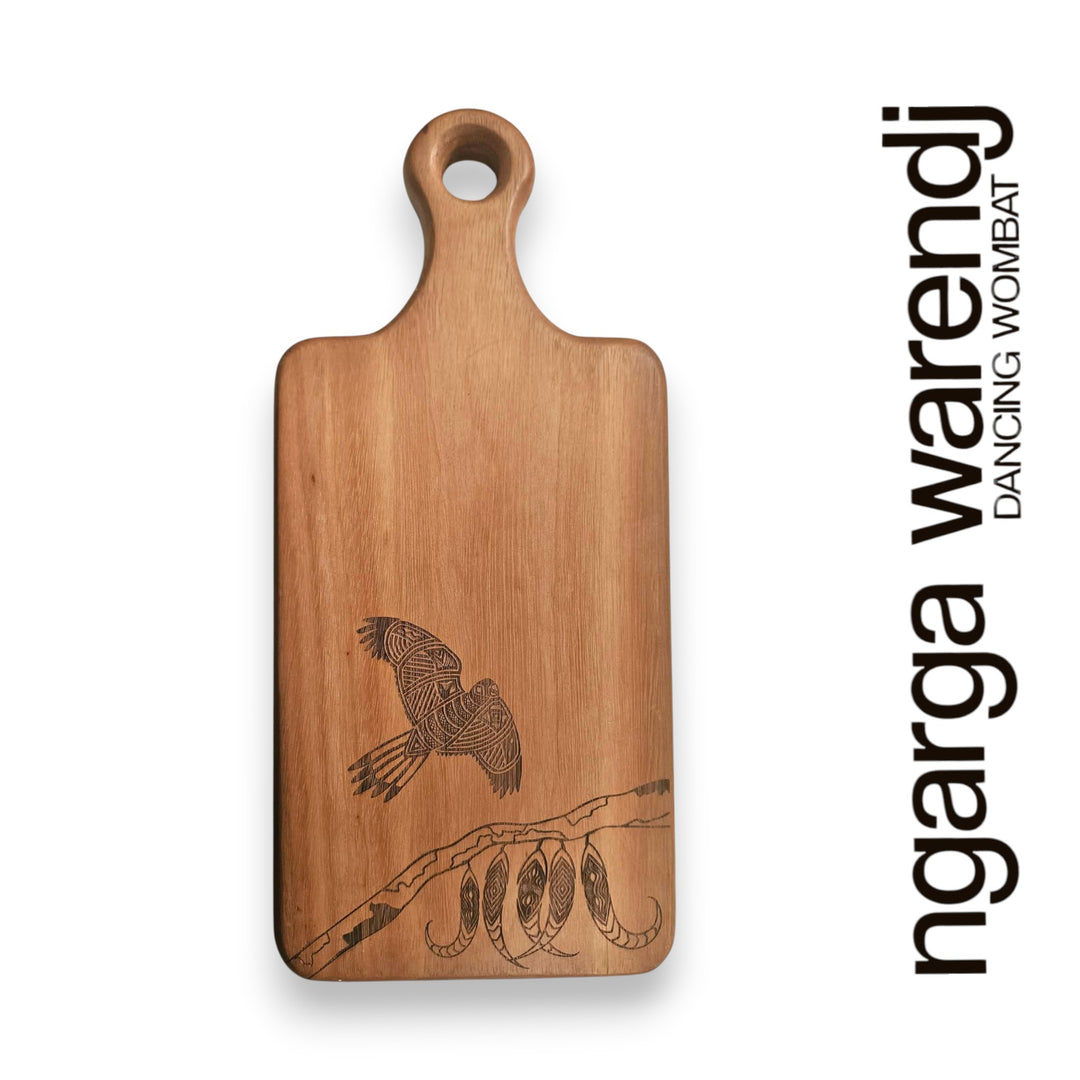 Wooden cutting board with engraved design on a white background, featuring the brand 'ngarga warendj'.
