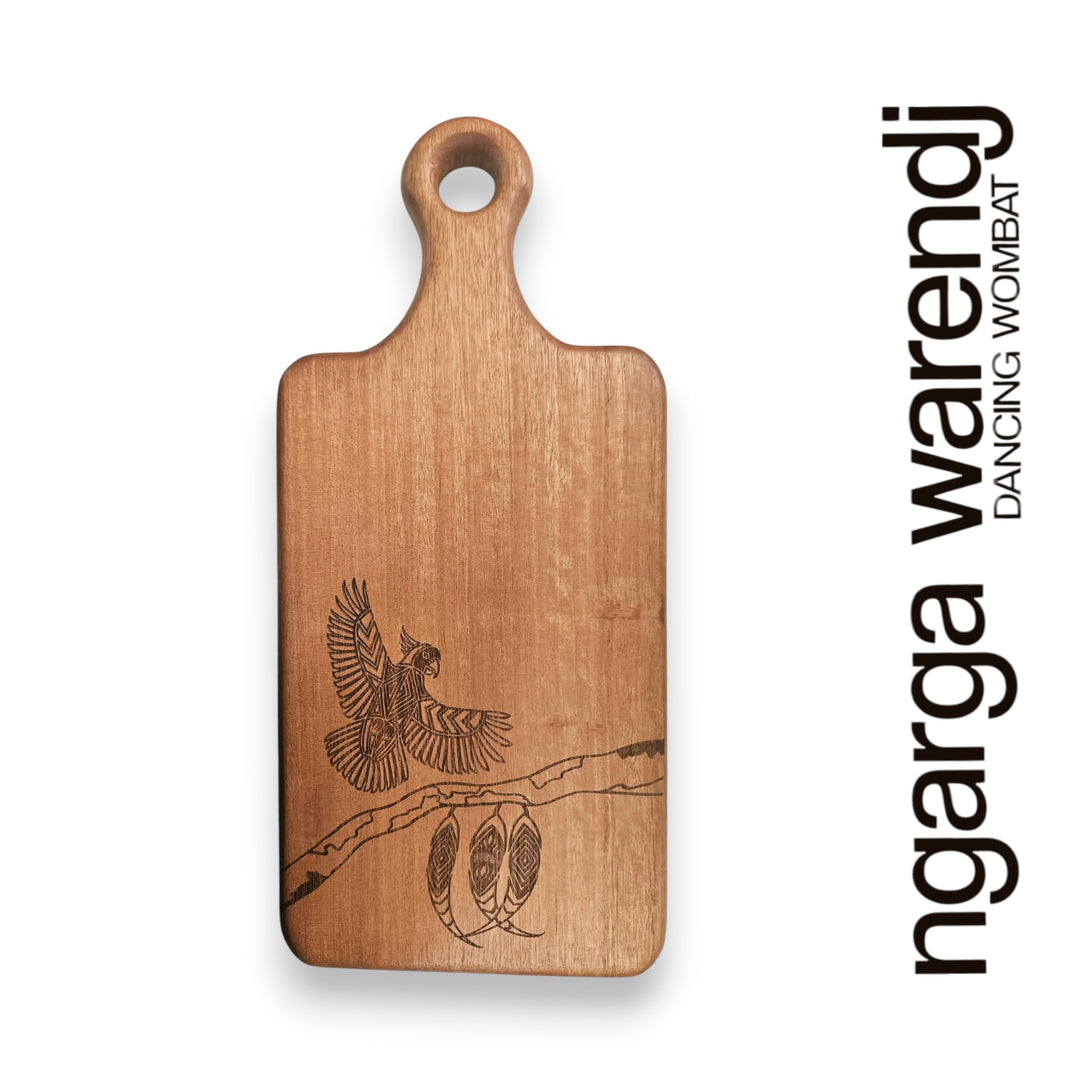 Wooden cutting board with bird design and 'ngarga warendj' branding on a white background