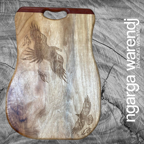 Bunjil the Wedge Tailed Eagle and Waa the Crow Board Made from Camphor Laurel with One Redgum Handle. Each board has its own distinct natural pattern and is embellished with a Bunjil Design by Ngarga Warendj - Dancing Wombat - based on the Traditional symbols of South Eastern Aboriginal Art. Your board comes with a card that gives the story of the artist and design.