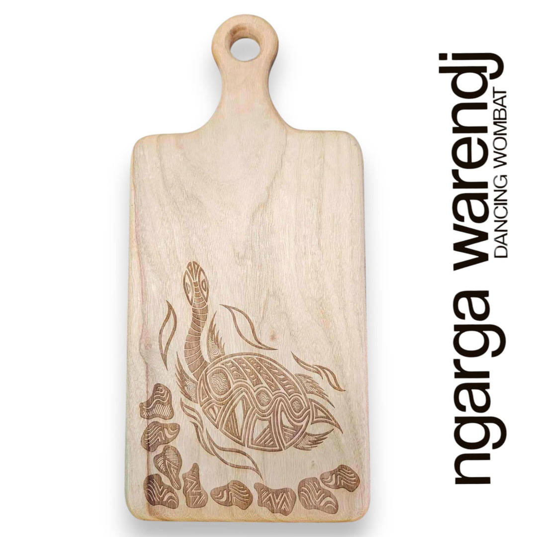 Wooden cutting board with turtle design and 'ngarga warendj' branding on a white background