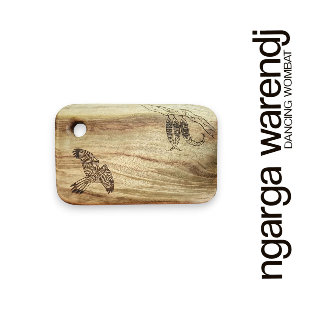 Wooden cutting board with laser-engraved designs on a white background, featuring the brand 'ngarga warendj'.