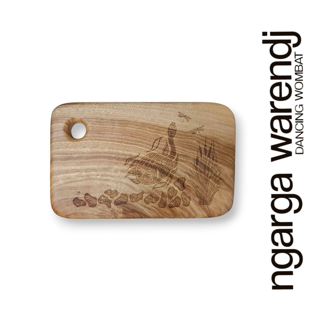Wooden cutting board with laser engraving on a white background, featuring the brand 'ngarga warendj'.