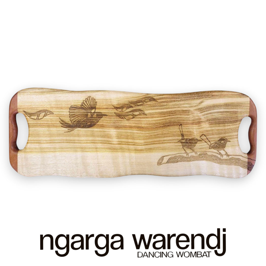Wooden cutting board with engraved designs on a white background, featuring the brand 'ngarga warendj'.