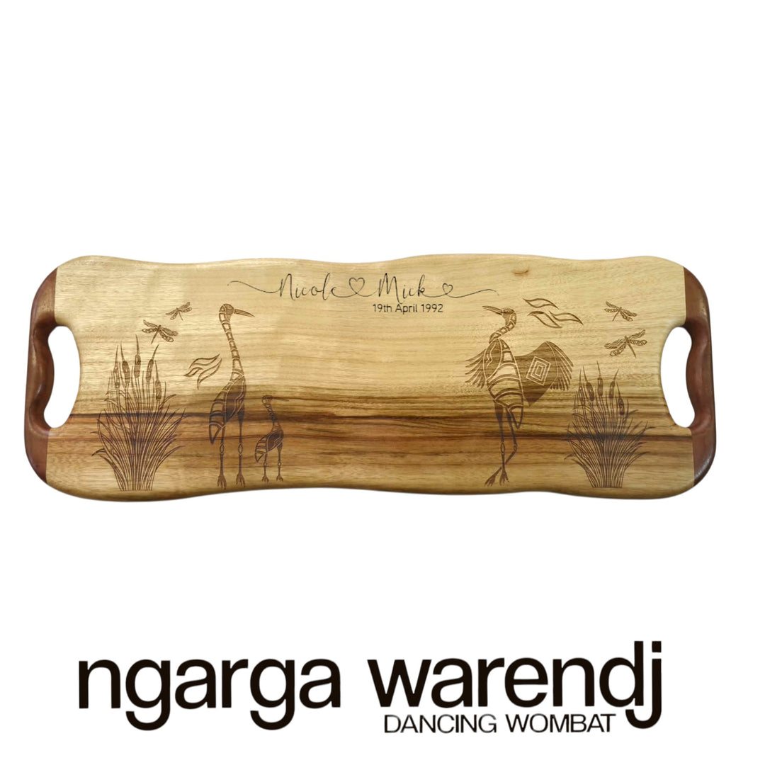 Wooden cutting board with engraved designs and text on a white background, featuring the brand 'ngarga warendj'.