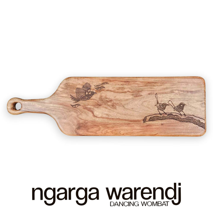 Wooden cutting board with engraved designs on a white background, featuring the brand 'ngarga warendj'.
