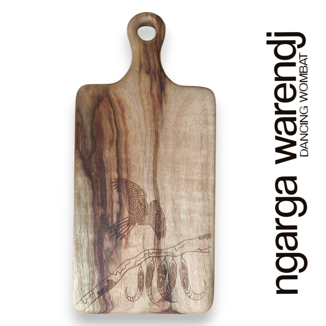 Wooden cutting board with engraved design on a white background, featuring the brand 'ngarga warendj'.