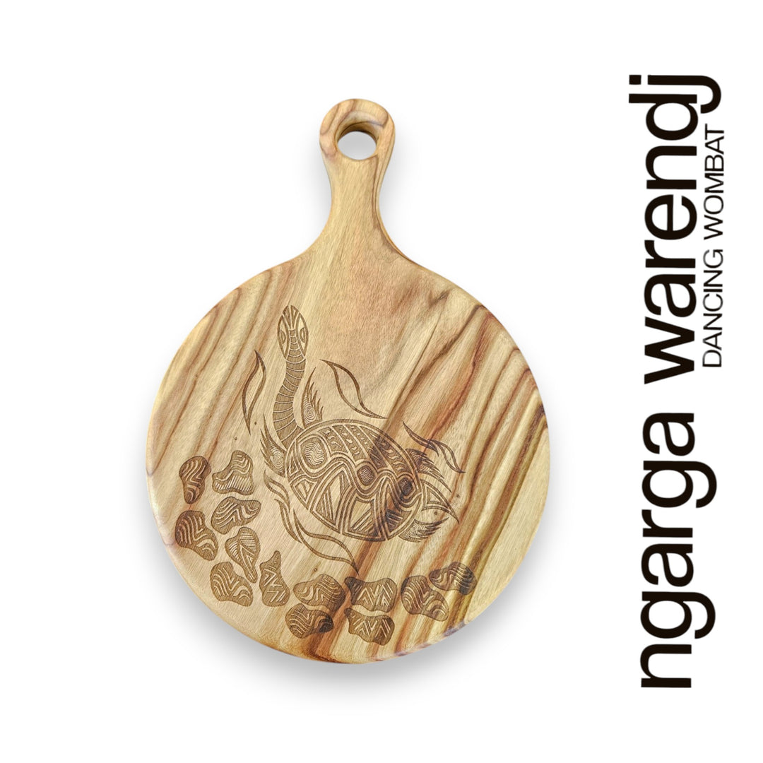 Wooden cutting board with laser engraving of a turtle design on a white background, featuring the brand 'ngarga warendj'.