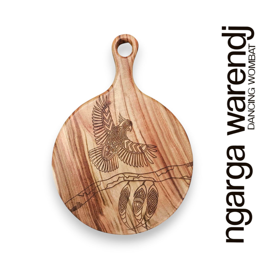 Wooden cutting board with engraved design on a white background, featuring the brand 'ngarga warendj'.