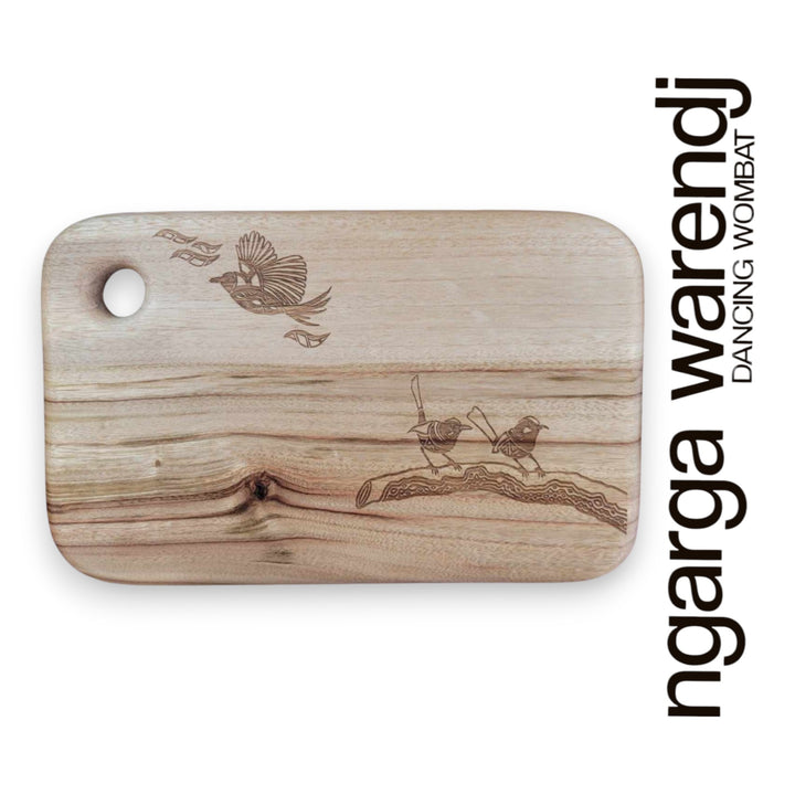 Wooden cutting board with laser-engraved designs on a white background, featuring the brand 'ngarga warendj'.