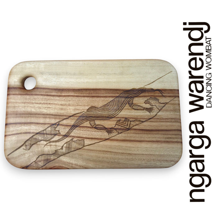Wooden cutting board with laser-engraved designs on a white background, featuring the brand 'ngarga warendj'.