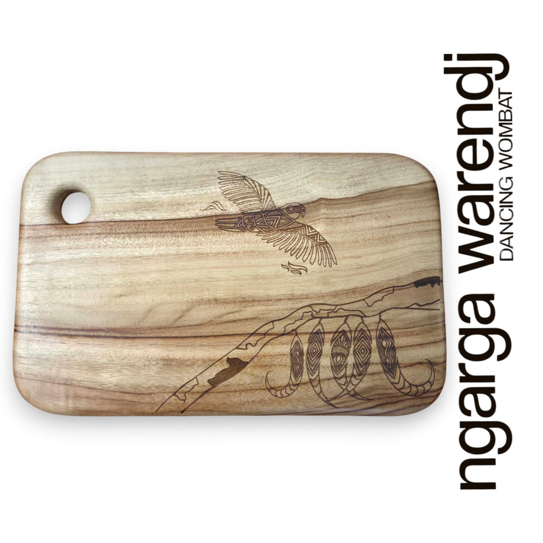 Wooden cutting board with laser-engraved designs on a white background, featuring the brand 'ngarga warendj'.