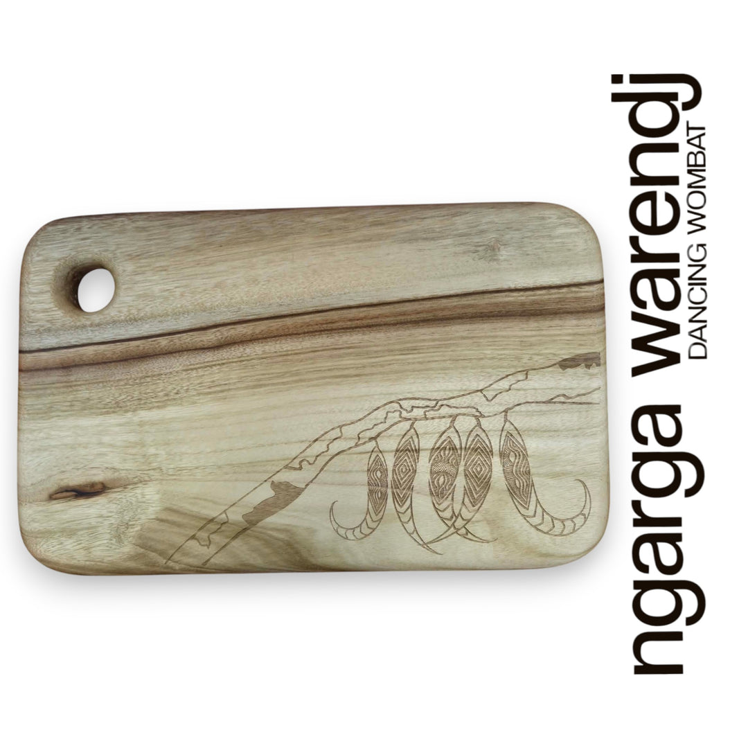 Wooden cutting board with laser-engraved designs on a white background, featuring the brand 'ngarga warendj'.