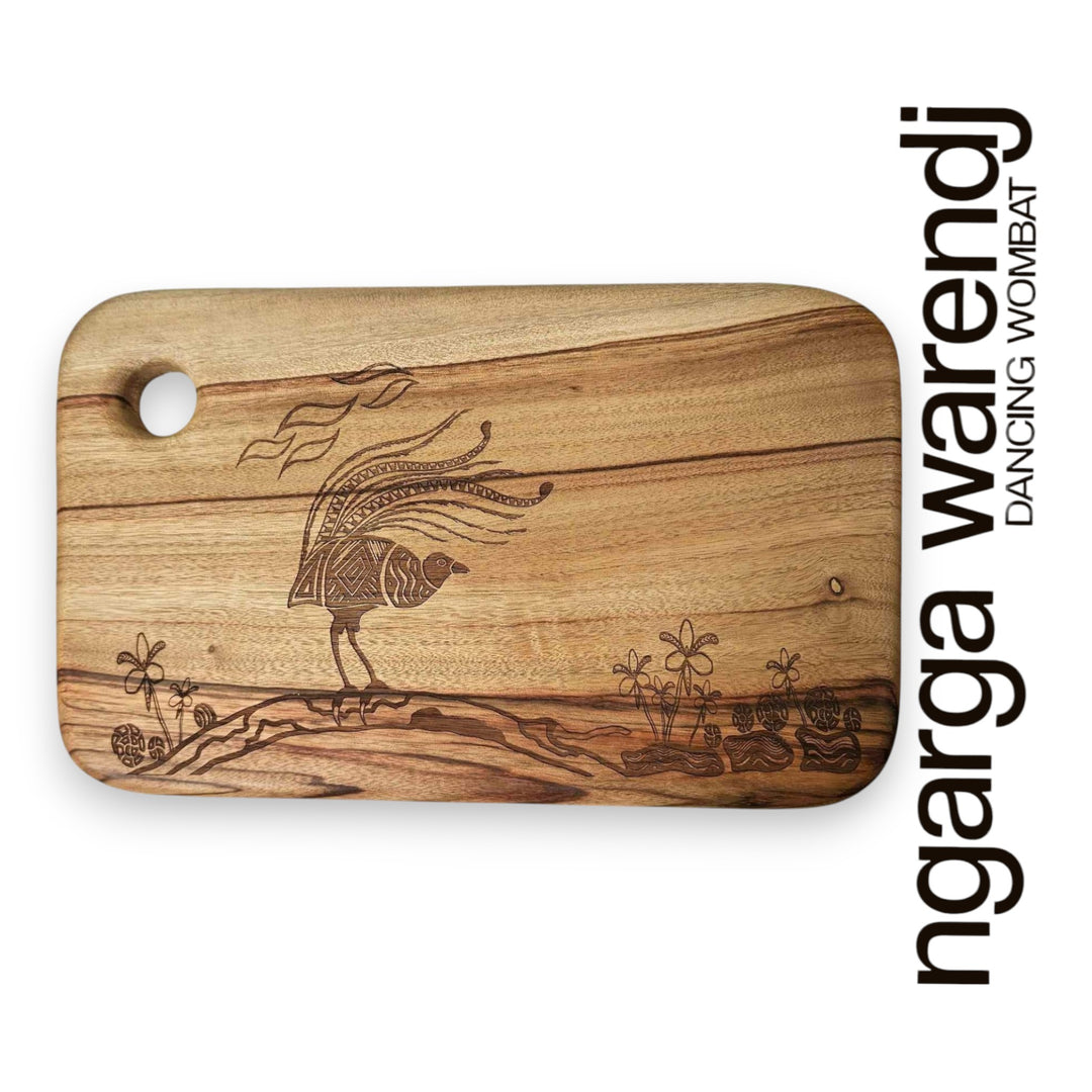 Wooden cutting board with engraved design on a white background, featuring the brand 'ngarga warendj'.
