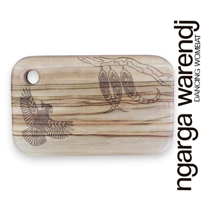 Wooden cutting board with laser-engraved designs on a white background, featuring the brand 'ngarga warendj'.