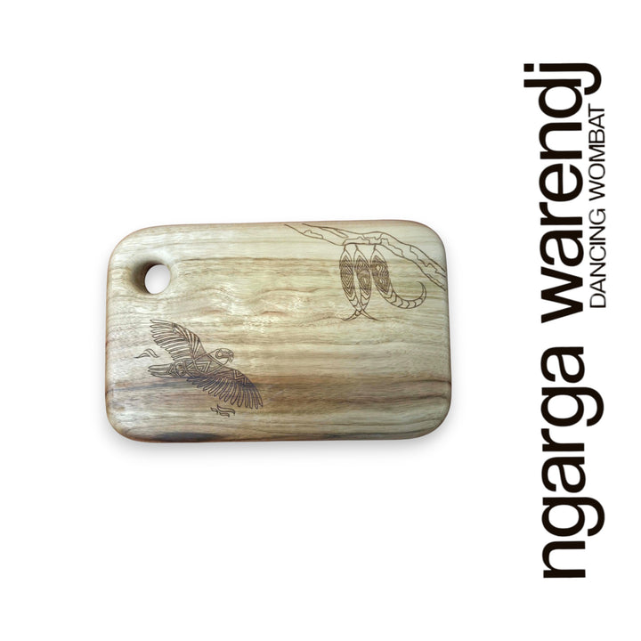 Wooden cutting board with engraved designs on a white background, featuring the brand 'ngarga warendj'.
