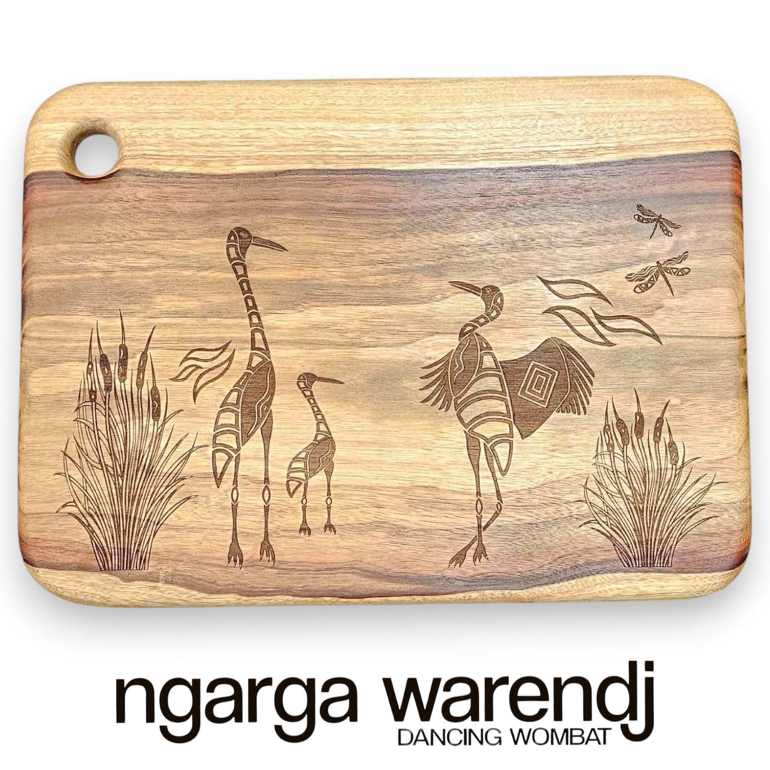 Wooden cutting board with engraved illustrations of animals and plants, featuring the brand 'ngarga warendj'.