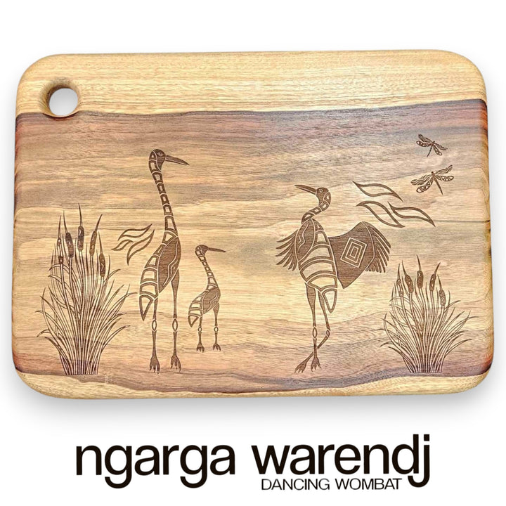 Wooden cutting board with engraved illustrations of animals and plants, featuring the brand 'ngarga warendj'.