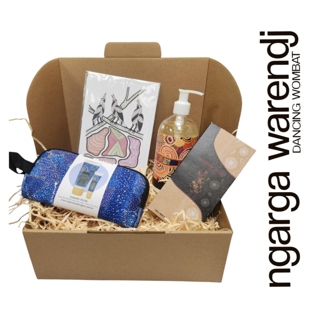Gift box with various items including a pouch with hand cream and lip balm , hand and body wash, chocolate and card, branded 'ngarga warendj'.