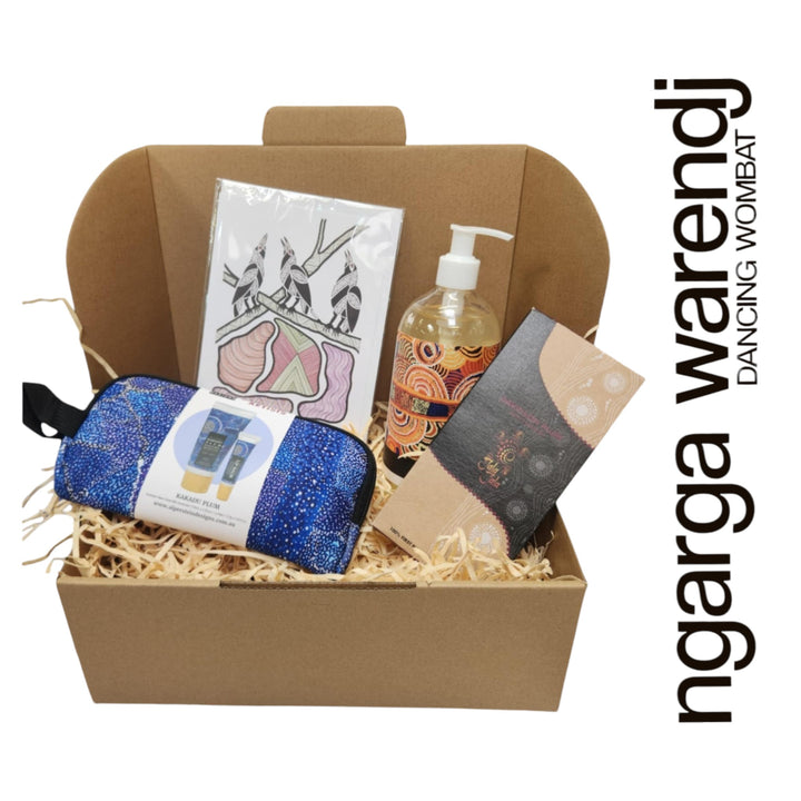 Gift box with various items including a pouch with hand cream and lip balm , hand and body wash, chocolate and card, branded 'ngarga warendj'.