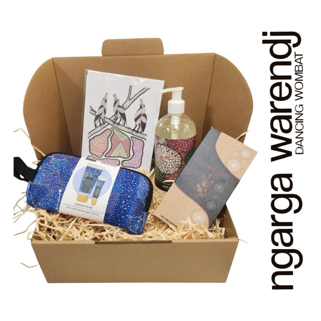 Gift box with various items including a pouch with hand cream and lip balm , hand and body wash, chocolate and card, branded 'ngarga warendj'.