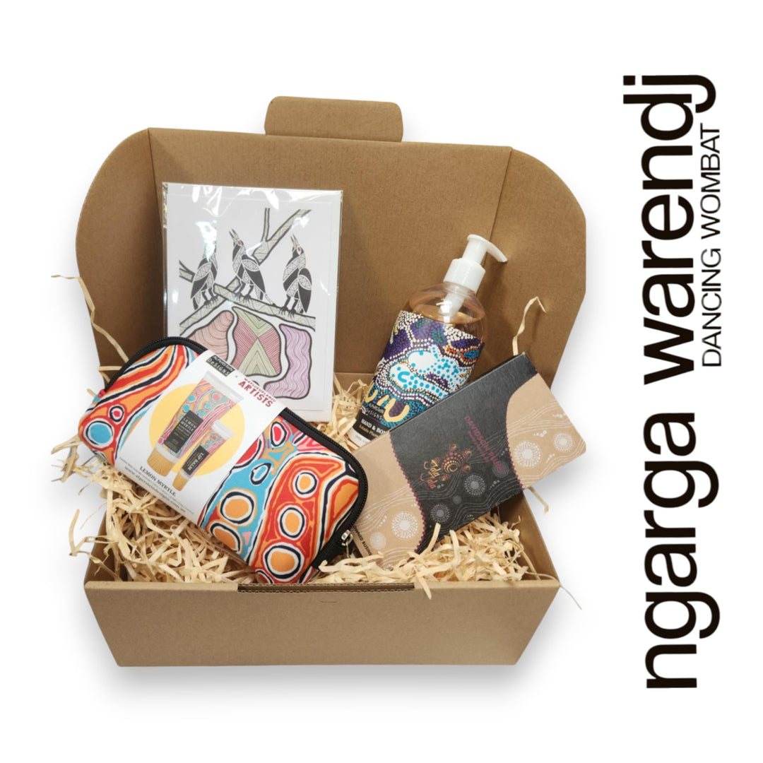 Gift box with various items including a pouch with hand cream and lip balm , hand and body wash, chocolate and card, branded 'ngarga warendj'.