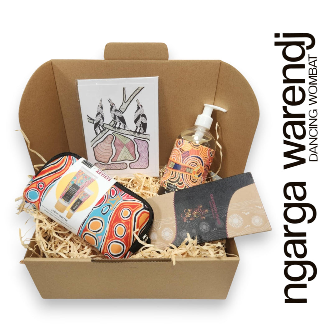 Gift box with various items including a pouch with hand cream and lip balm , hand and body wash, chocolate and card, branded 'ngarga warendj'.
