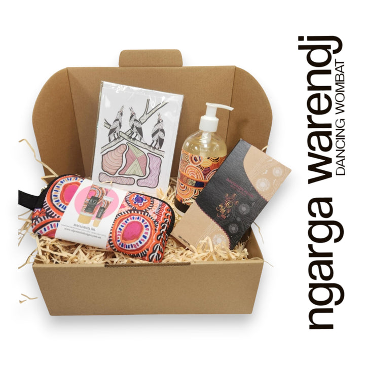 Gift box with various items including a pouch with hand cream and lip balm , hand and body wash, chocolate and card, branded 'ngarga warendj'.