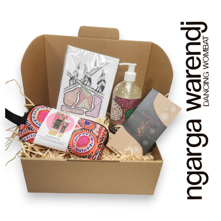Gift box with various items including a pouch with hand cream and lip balm , hand and body wash, chocolate and card, branded 'ngarga warendj'.