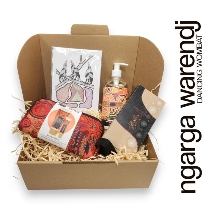 Gift box with various items including a pouch with hand cream and lip balm , hand and body wash, chocolate and card, branded 'ngarga warendj'.