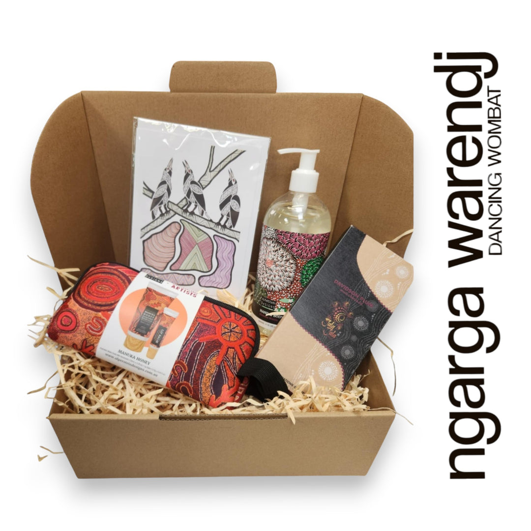Gift box with various items including a pouch with hand cream and lip balm , hand and body wash, chocolate and card, branded 'ngarga warendj'.