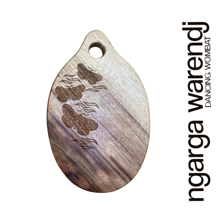 Wooden pendant with engraved designs on a white background, featuring the brand 'ngarga warendj'.