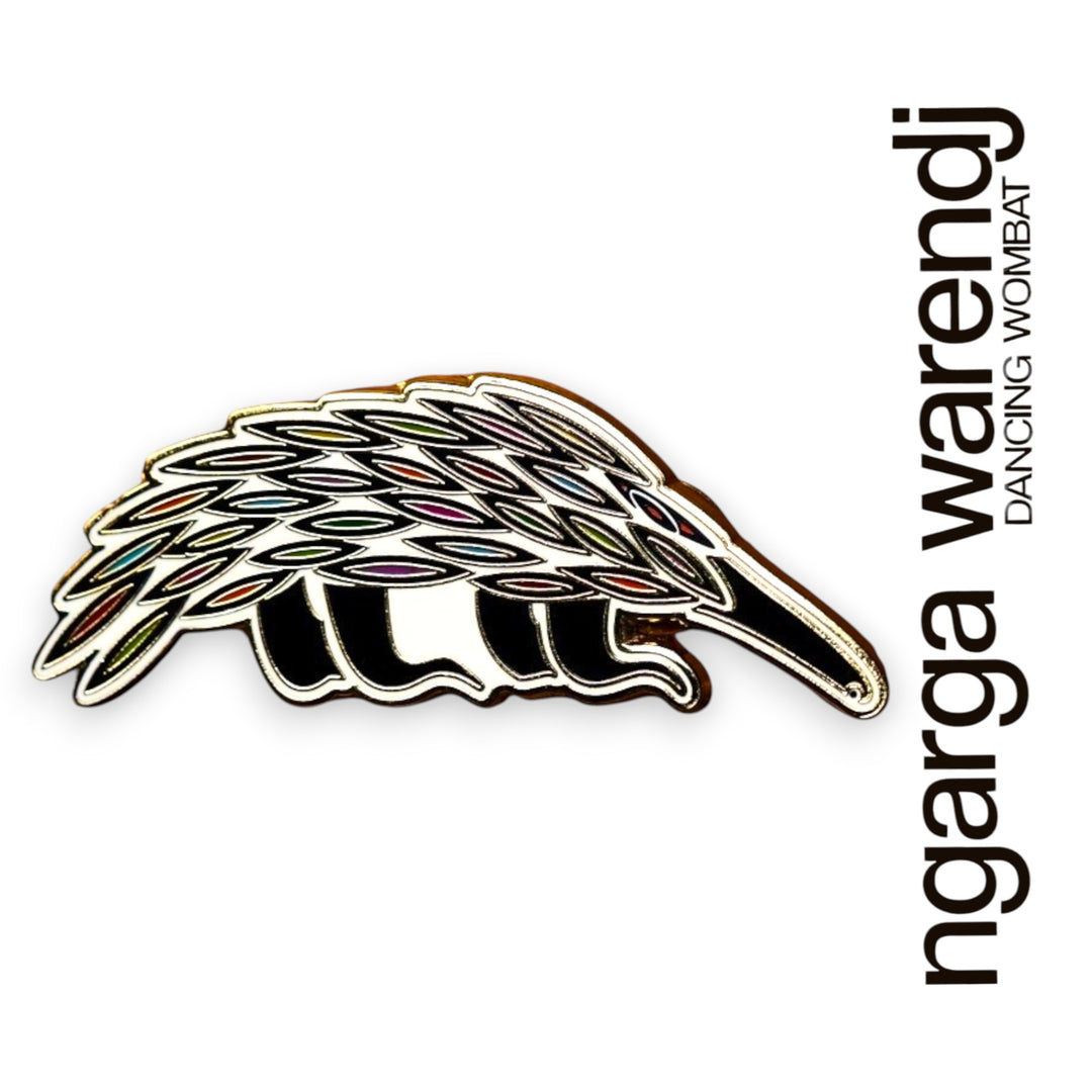 Decorative Echidma lapel pin with gold border on a white background, featuring the brand 'ngarga warendj'.
