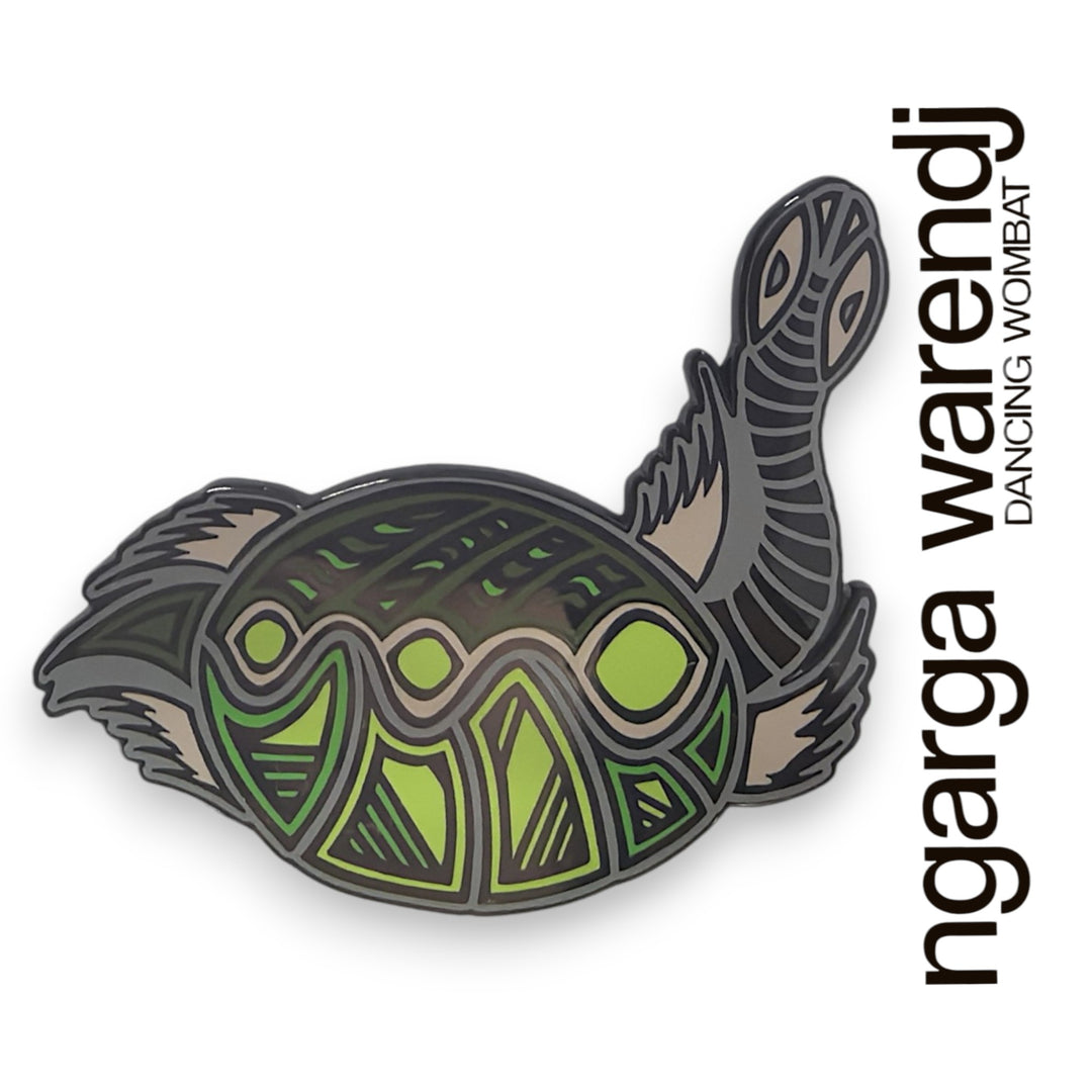 Decorative turtle-shaped lapel pin with green and brown patterns on a white background, featuring the brand 'ngarga warendj'.