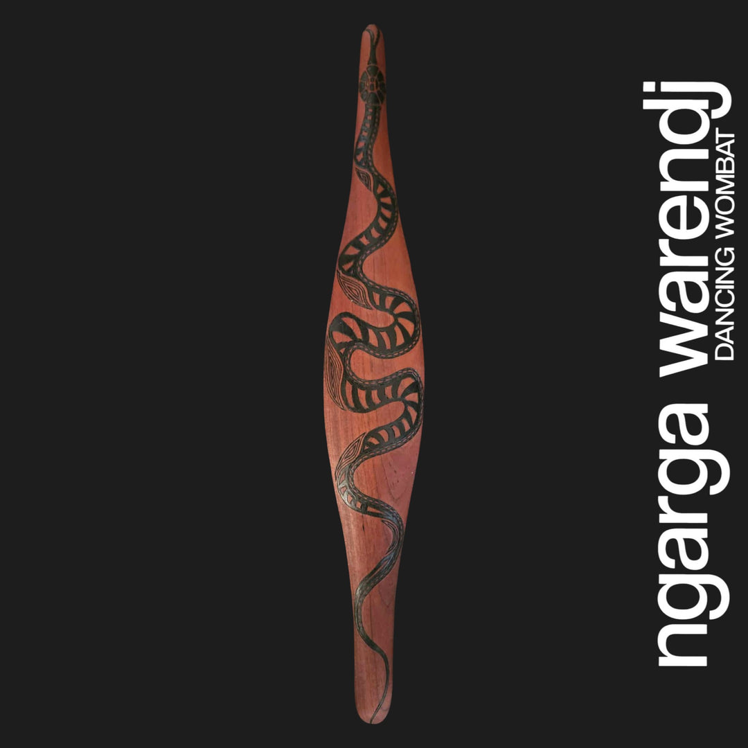 Wooden shieldwith snake design on a black background, featuring the brand 'ngarga warendj'.
