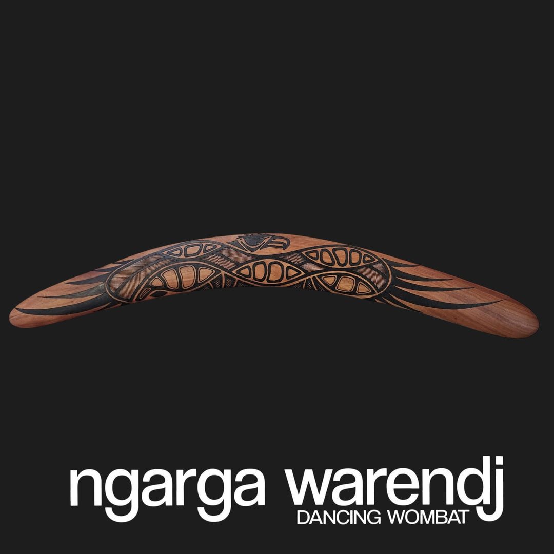 Decorative boomerang with intricate patterns on a black background, featuring the brand 'ngarga warendj'.
