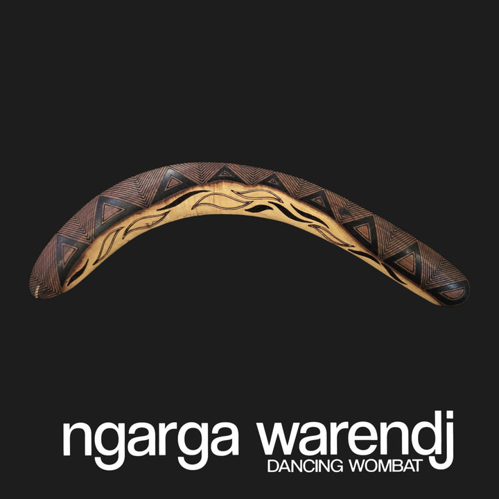 Decorative boomerang with tribal patterns on a black background, featuring the brand 'ngarga warendj'.