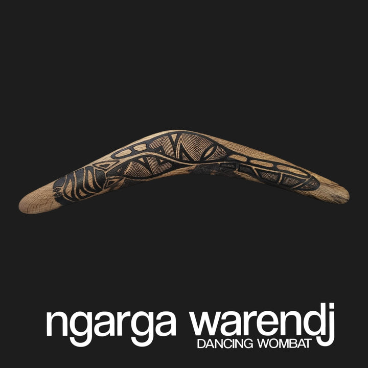 Decorative boomerang with Aboriginal design on a black background, featuring the brand 'ngarga warendj'.