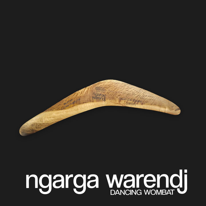 Wooden boomerang with 'ngarga warendj' branding on a black background