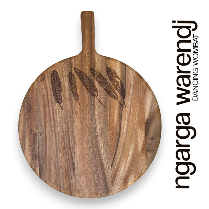 Wooden cutting board with engraved designs on a white background, featuring the brand 'ngarga warendj'.