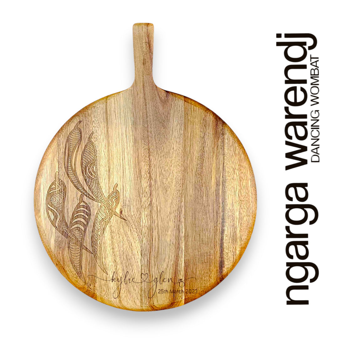 Wooden cutting board with engraved design on a white background, featuring the brand 'ngarga warendj'.