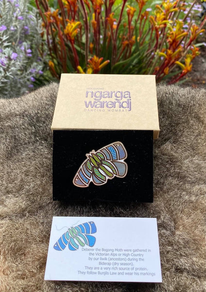 Add a finishing touch to any outfit, with this Lapel Pin featuring a Blue Bogong Moth design by Ngarga Warendj Dancing Wombat Measures 50mm x 36.8mm  Presented in a stylish box with magnetic closure  Information card included - with information on the design and artist  Metal with Enamel Inlay