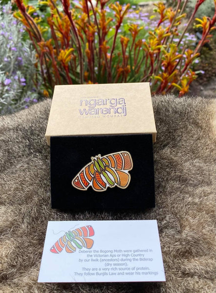 Add a finishing touch to any outfit, with this Lapel Pin featuring an Orange Bogong Moth design by Ngarga Warendj Dancing Wombat  Measures 50mm x 36.8mm  Presented in a stylish box with magnetic closure  Made from metal with enamel inlay Information card included - with information on the design and artist 