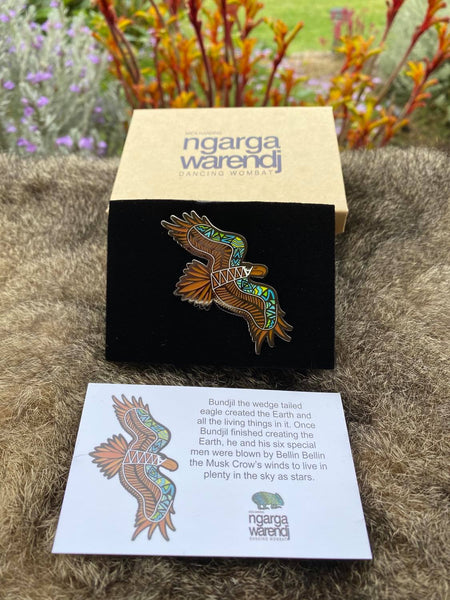 This Lapel Pin featuring our Bunjil the Wedge Tailed Eagle design by Ngarga Warendj (Dancing Wombat), will add a finishing touch to any outfit, Perfect for corporate gift giving, as it comes presented in a stylish box with magnetic closure. The card included gives information on the design and artist, Mick Harding. Measures 60mm x 36.6mm  Card included with information on the design and artist, Mick Harding Presented in a stylish box with magnetic closure  Made from metal with enamel inlay