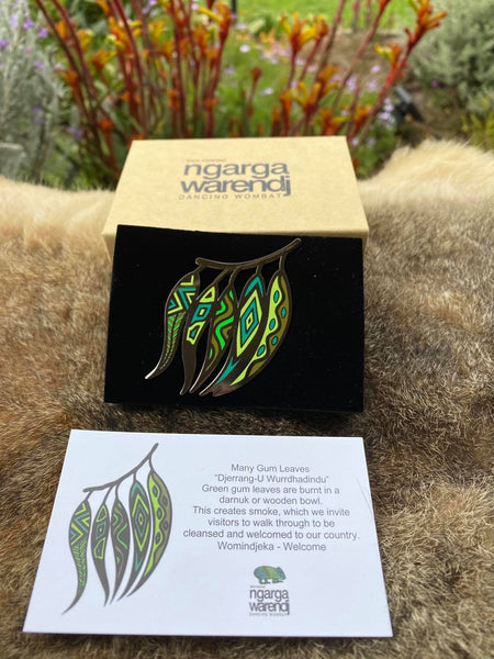 Add a finishing touch to any outfit, with this Lapel Pin featuring our Gum Leaves design by Ngarga Warendj (Dancing Wombat). Perfect for corporate gift giving, as it comes presented in a stylish box with magnetic closure.  The card included gives information on the design and artist, Mick Harding.  Measures 60mm x 42.5 cm.  Made from metal with Enamel Inlay
