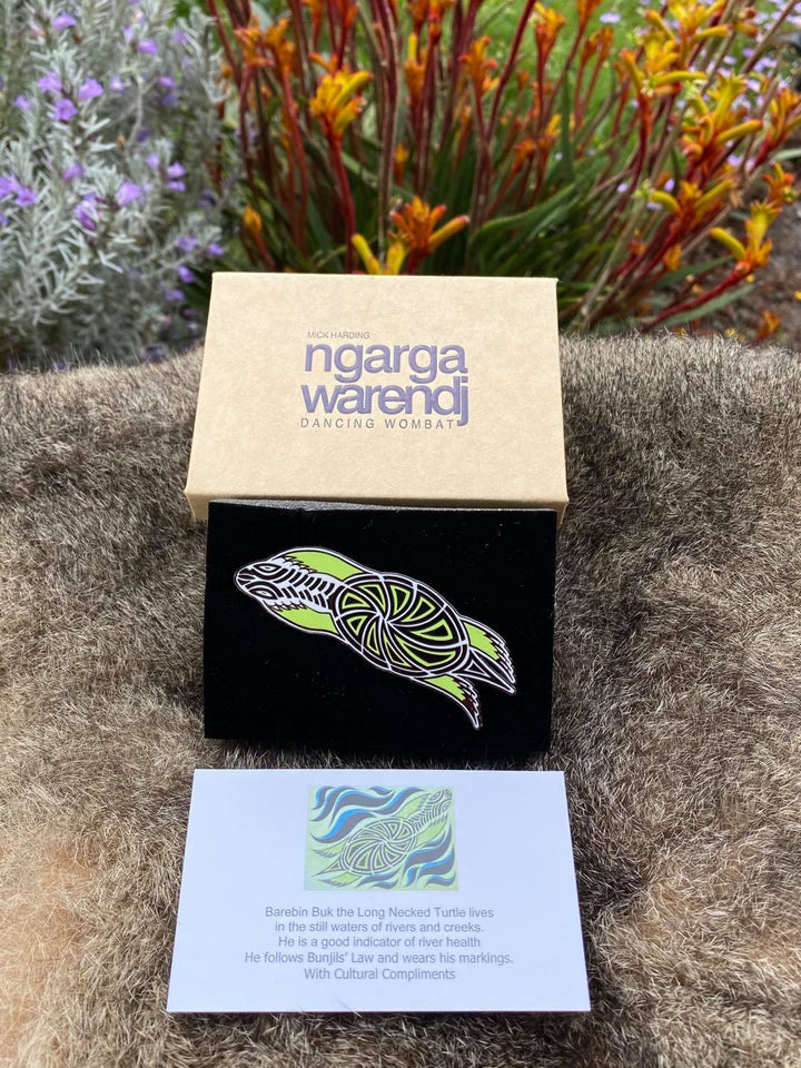In its stylish box, with magnetic closure, this pin is ready for gift giving  This Lapel Pin featuring our Turtle design by Ngarga Warendj (Dancing Wombat), will add a finishing touch to any outfit. Measures 68mm x 47.1mm  Presented in a stylish box with magnetic closure  Made from metal with enamel inlay Information card included - with information on the design and artist