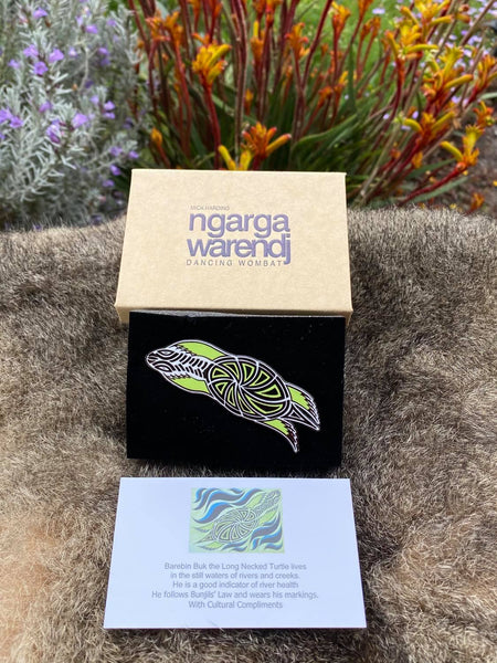 In its stylish box, with magnetic closure, this pin is ready for gift giving  This Lapel Pin featuring our Turtle design by Ngarga Warendj (Dancing Wombat), will add a finishing touch to any outfit. Measures 68mm x 47.1mm  Presented in a stylish box with magnetic closure  Made from metal with enamel inlay Information card included - with information on the design and artist