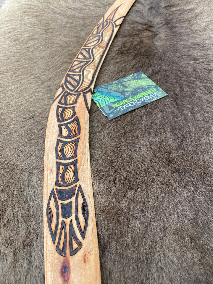 Large BareBin Buk the Turtle  Wangim / Boomerang. Made from Stringybark  timber.  Hand Crafted in Australia.  All artefacts come with an information card.  The card has information about the artist, artefact and design. All our wangim are made from timber collected from tree roots or branches that have a natural bend. All designs are based on traditional symbols from South East Australia
