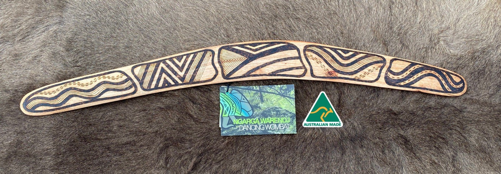 Medium Gugra Possum Skin Cloak Wangim / Boomerang. Made from Stringybark timber.  Hand Crafted in Australia.  All artefacts come with an information card.  The card has information about the artist, artefact and design. All our wangim are made from timber collected from tree roots or branches that have a natural bend. All designs are based on traditional symbols from South East Australia