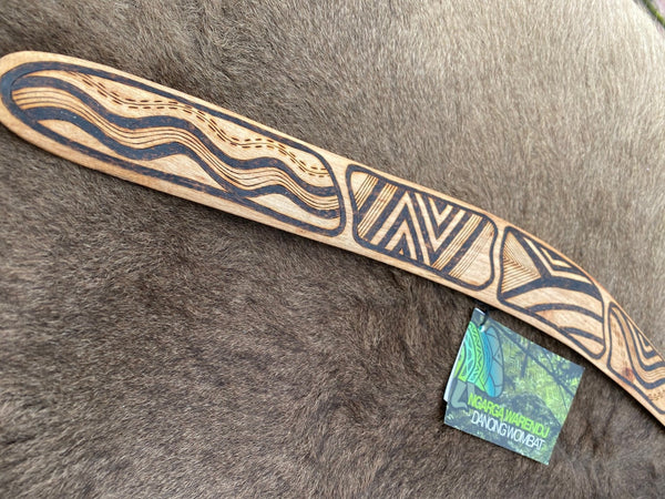Medium Gugra Possum Skin Cloak Wangim / Boomerang. Made from Stringybark timber.  Hand Crafted in Australia.  All artefacts come with an information card.  The card has information about the artist, artefact and design. All our wangim are made from timber collected from tree roots or branches that have a natural bend. All designs are based on traditional symbols from South East Australia